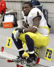 Michigan running back Brandon Minor (4) watches the scoreboard as the clock runs out during the the fourth quarter of Michigan's 42-7 loss to the Buckeyes. (AP Photo/Charles Rex Arbogast)